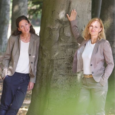 Frauen in Führungspositionen, Teamführung, 2 Frauen an einen Baum gelehnt