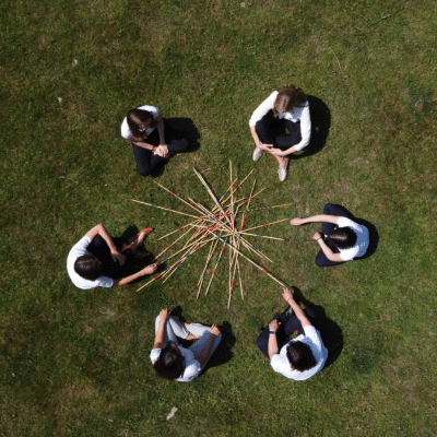 Teamführung, Teammeeting gestalten, Frauen sitzen im Kreis vor Mikadostäben
