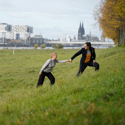 Führungskräfte Coaching, CliftonStrengths für Führungskräfte, Frau reicht einer anderen Frau helfend die Hand